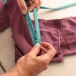 seamstress testing the operation of a zipper in her sewing shop