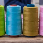 Spool of sewing thread. Multicolor sewing threads. Colored sewing threads.