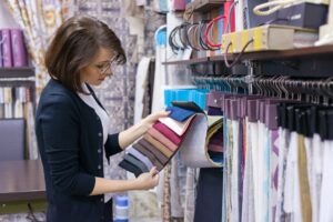 Woman designer, decorator chooses fabrics for curtains
